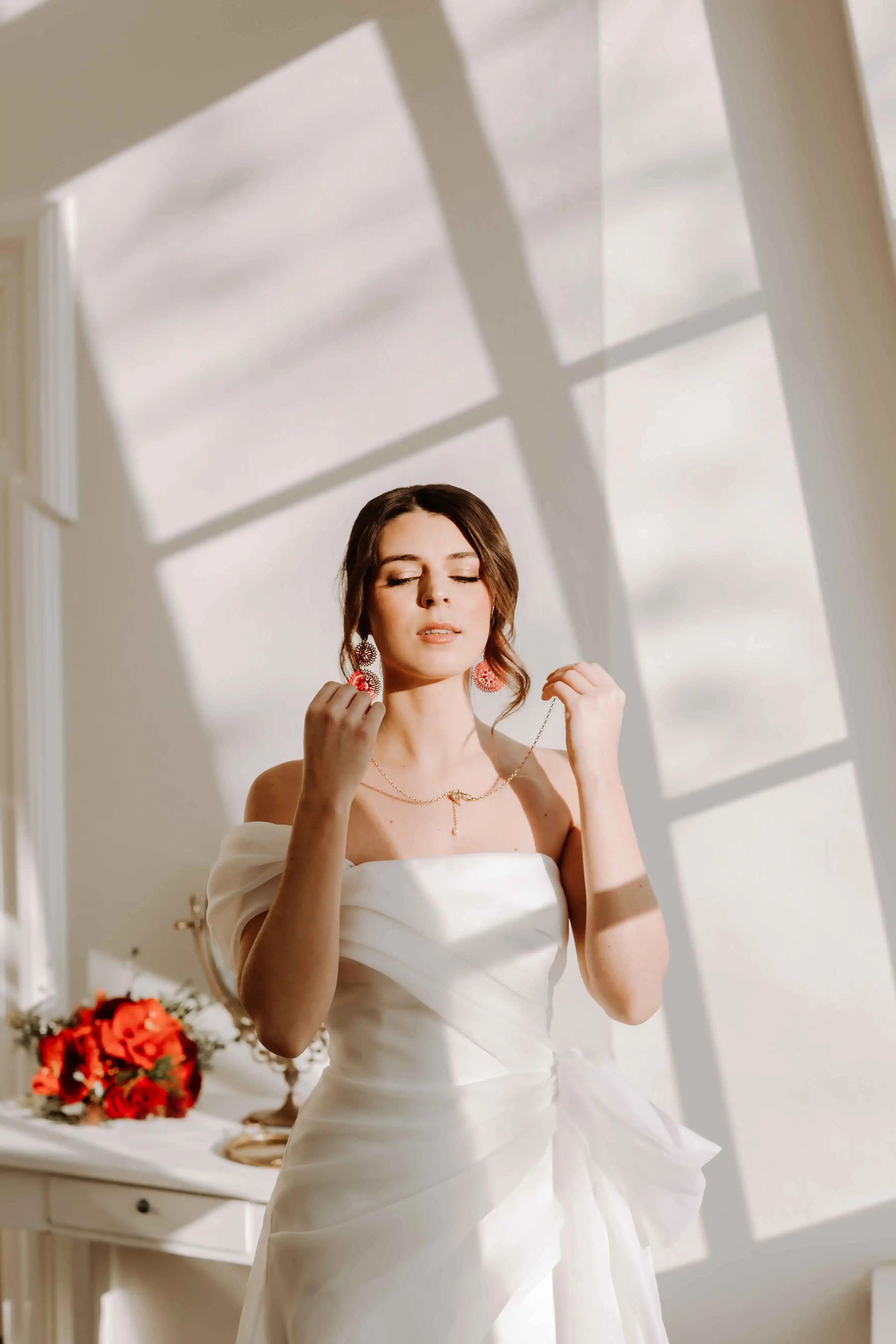 Elegante Braut beim Anlegen des Hochzeitsschmucks, Dezember Wedding